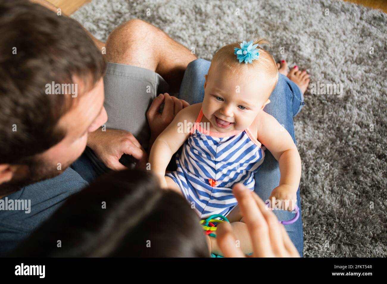 High angle view of mid adult couple jouant avec sa petite fille sur les genoux Banque D'Images