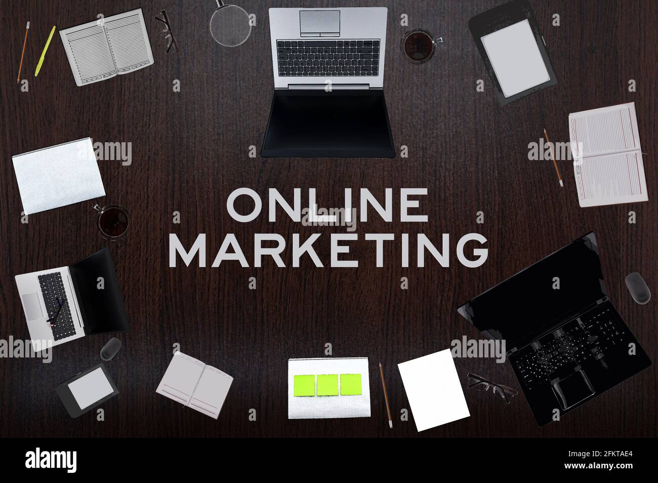 Concept de marketing en ligne. Mise en page supérieure de dessins d'ordinateurs portables, de blocs-notes, de café, de différentes affaires sur fond noir. Banque D'Images