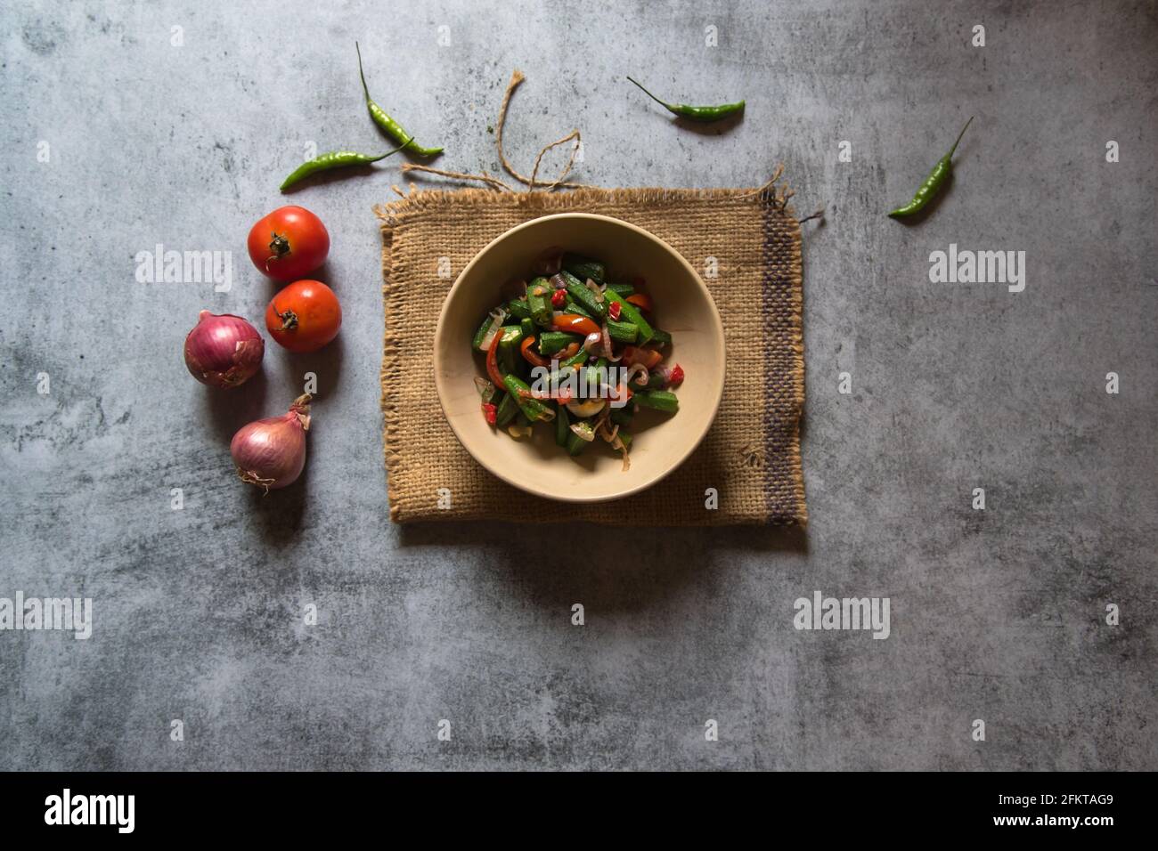 Préparation de légumes indiens Okra ou frits doigt pour femmes dans un bol. Vue de dessus. Banque D'Images