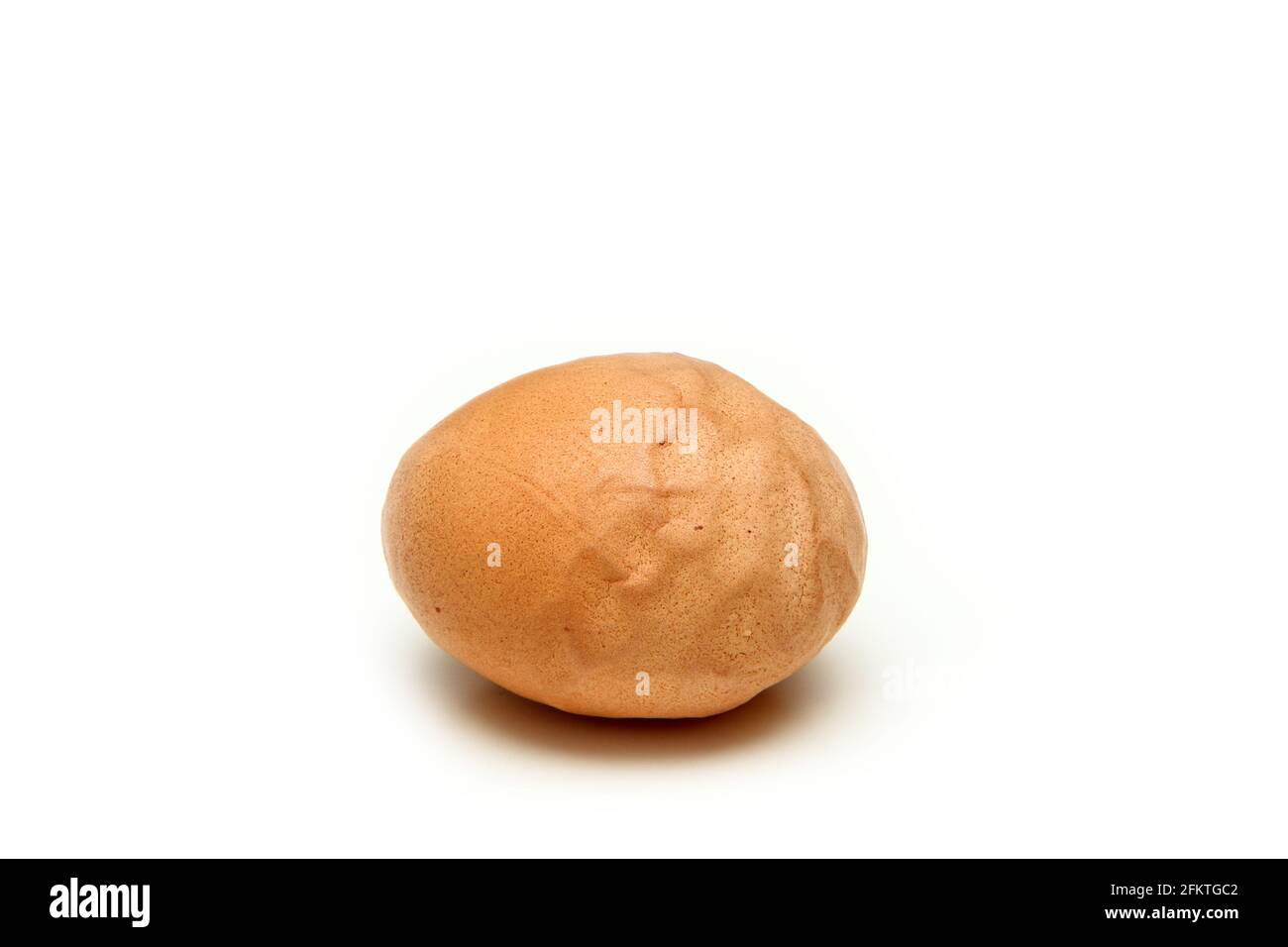 L'œuf biologique à la coquille d'œuf rugueuse et ondulée. Isolé sur fond blanc. La raison peut être la vieille poule, une alimentation insuffisante ou un mauvais processus de forme Banque D'Images