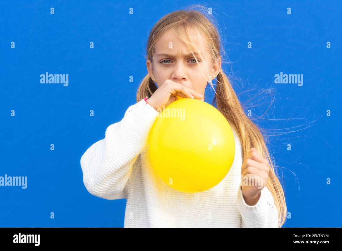Gros plan photo de belle jolie fille gonfler ballon ont temps libre positif  gai drôle fille isolée sur fond bleu coloré. Élevée Photo Stock - Alamy