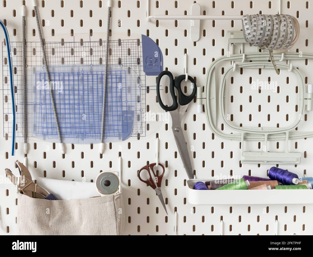 Panneau perforé blanc avec fournitures de couture. Concept de  personnalisation et de travail des aiguilles, rangement ergonomique Photo  Stock - Alamy