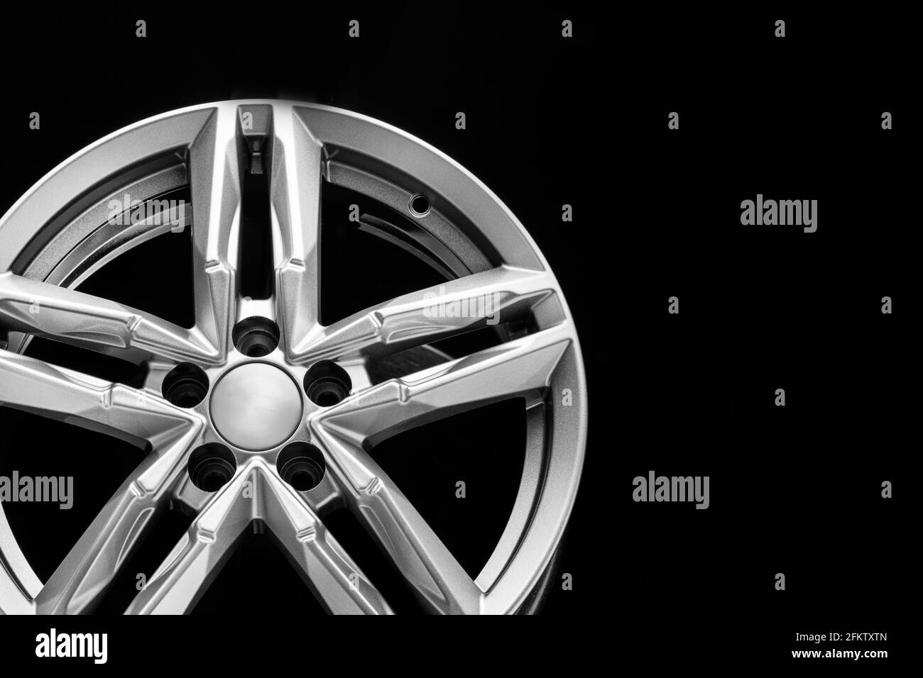 roue en alliage d'argent avec poutres bifurquées sur fond noir, espace de copie. Banque D'Images