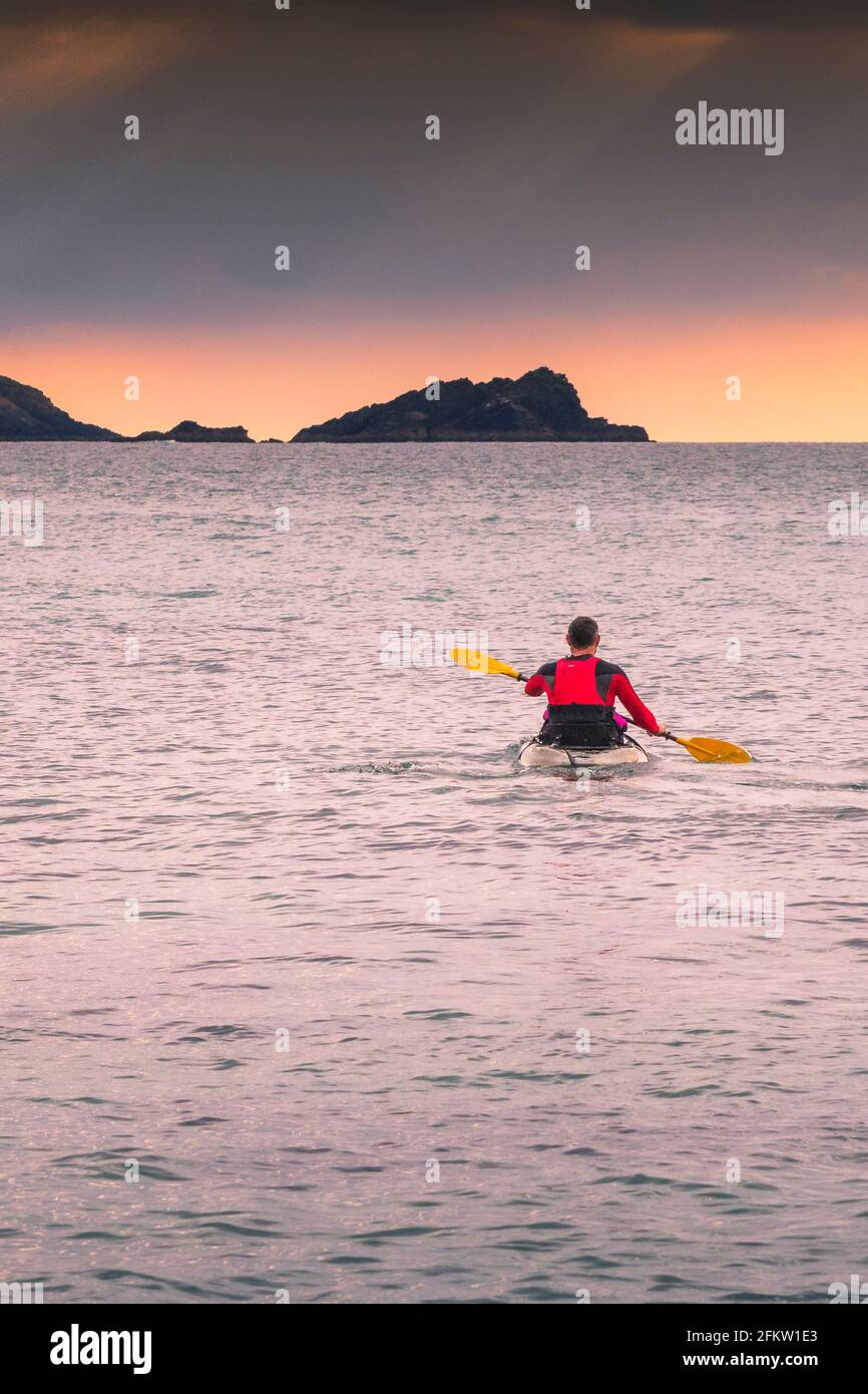 Un kayakiste pagayant sur la mer à Fistral Bay, à Newquay, en Cornouailles. Banque D'Images