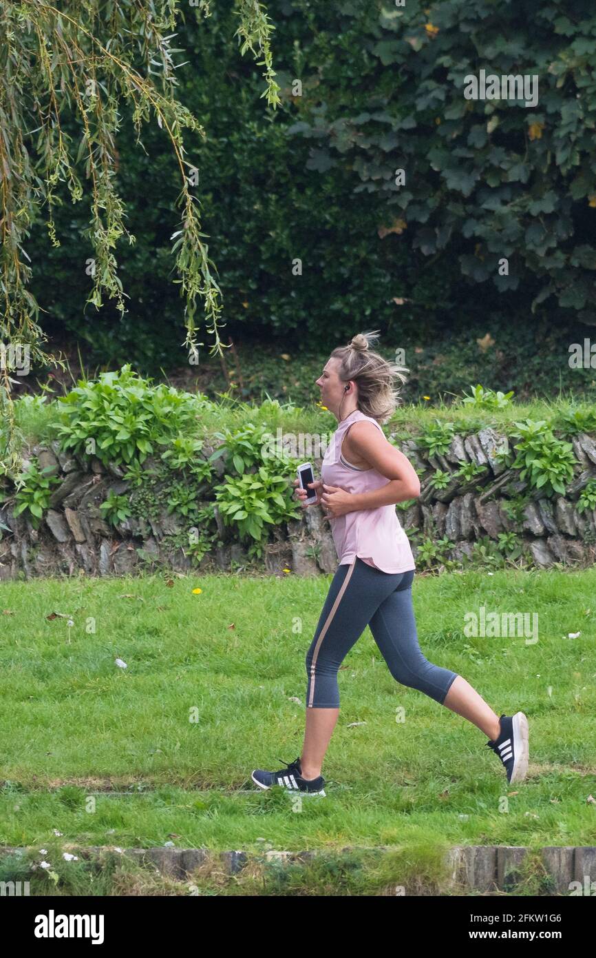 Une femme qui court dans un parc. Banque D'Images