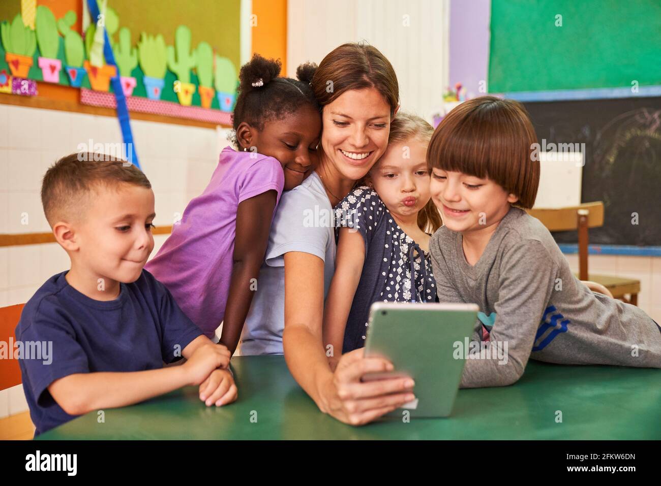 L'enseignant de maternelle et les enfants prennent un selfie dans la maternelle internationale pour les médias sociaux Banque D'Images