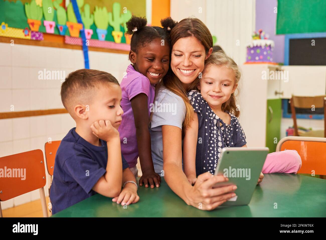 Les enfants et les éducateurs prennent un selfie avec un ordinateur tablette jardin d'enfants international Banque D'Images