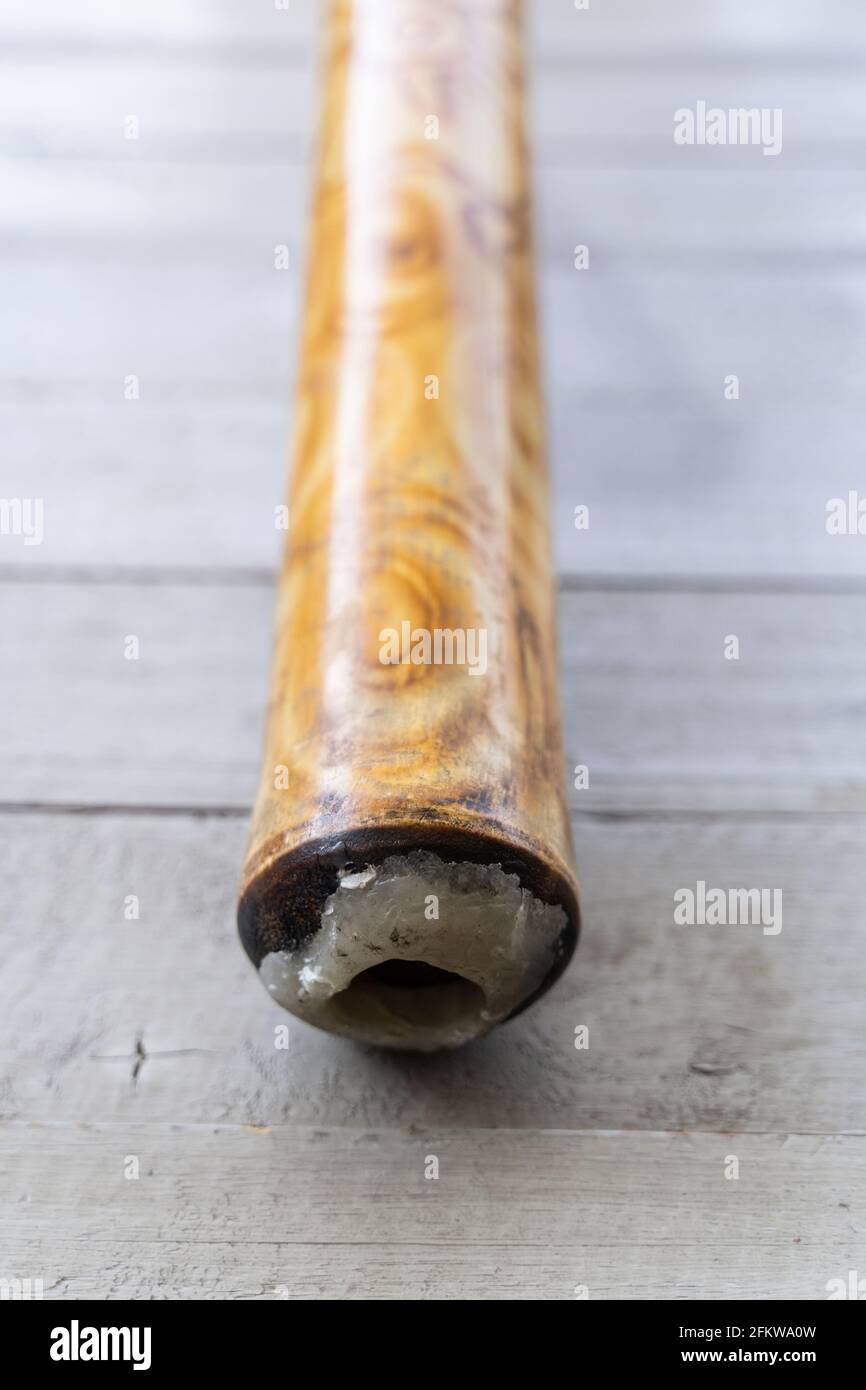 Didgeridoo silicone bouche fermé. Instrument de musique australien traditionnel en bois et décoré de motifs abstraits Banque D'Images