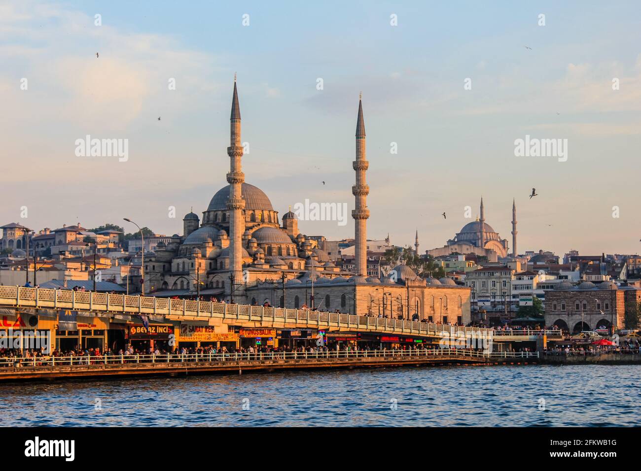 Istanbul, Turquie - 12 mai 2013 : les gens traversent le pont de Galate avec la nouvelle mosquée en arrière-plan Banque D'Images