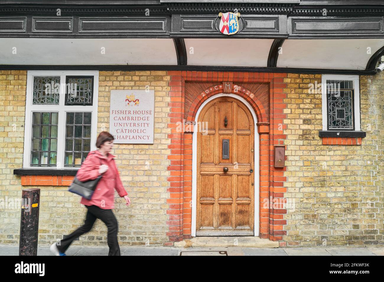 Une femme passe devant Fisher House, aumônerie catholique, université de Cambridge, Angleterre. Banque D'Images
