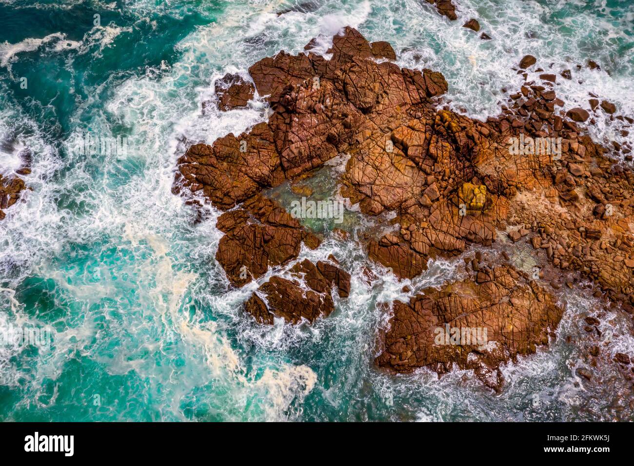 Vue aérienne de l'océan bleu se lavant autour de l'environnement gravé rochers et rochers Banque D'Images
