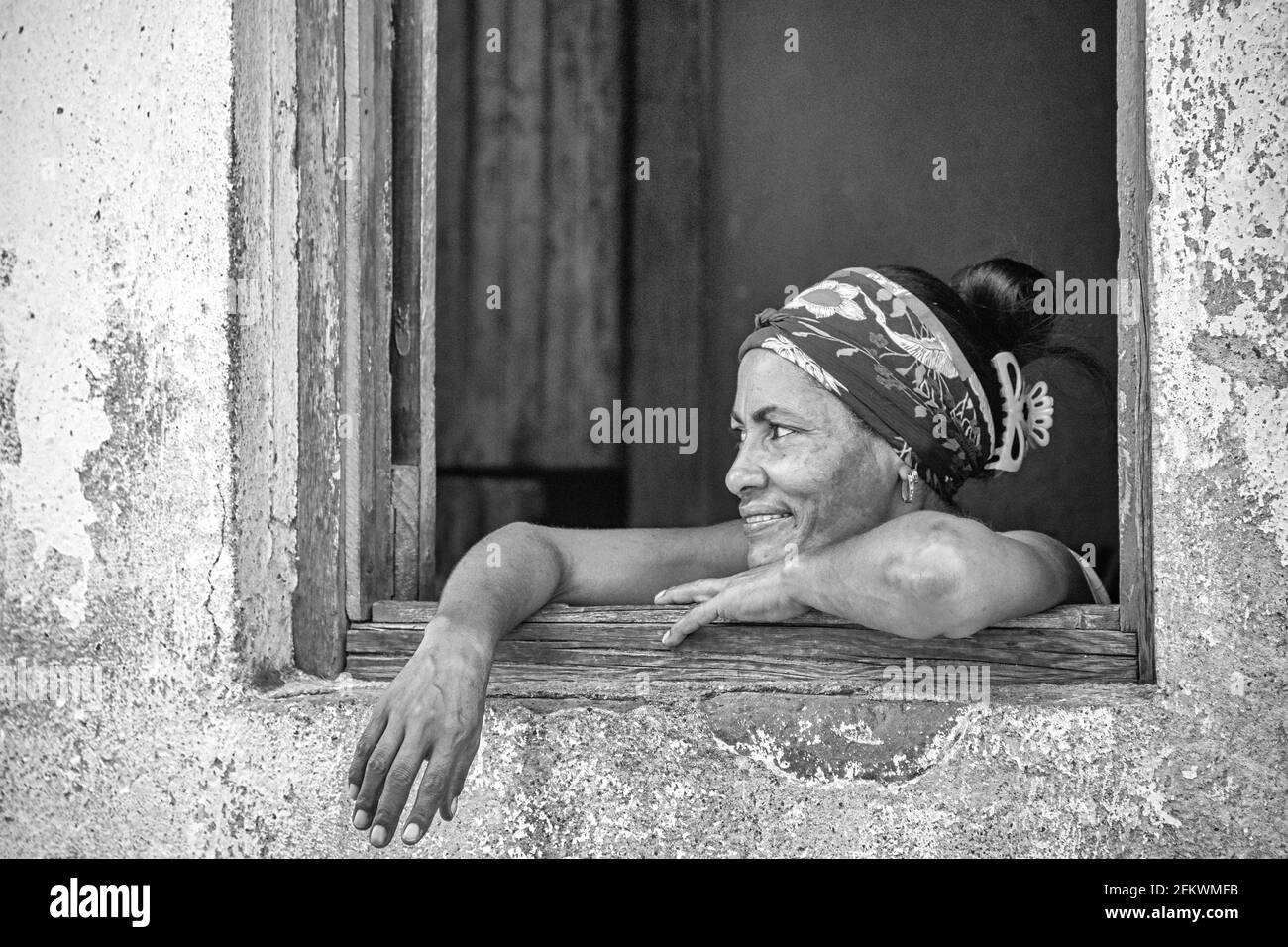 Portrait d'une femme cubaine dans une fenêtre d'une maison altérée, Cuba. Année 2016 Banque D'Images