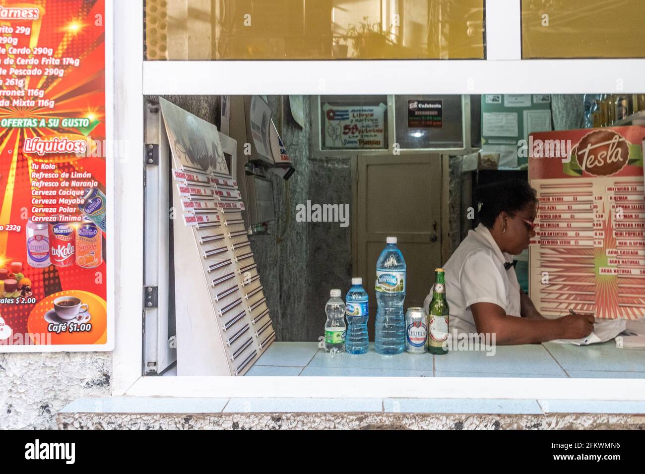 Une femme qui équilibre les livres dans une cafétéria, Cuba Banque D'Images