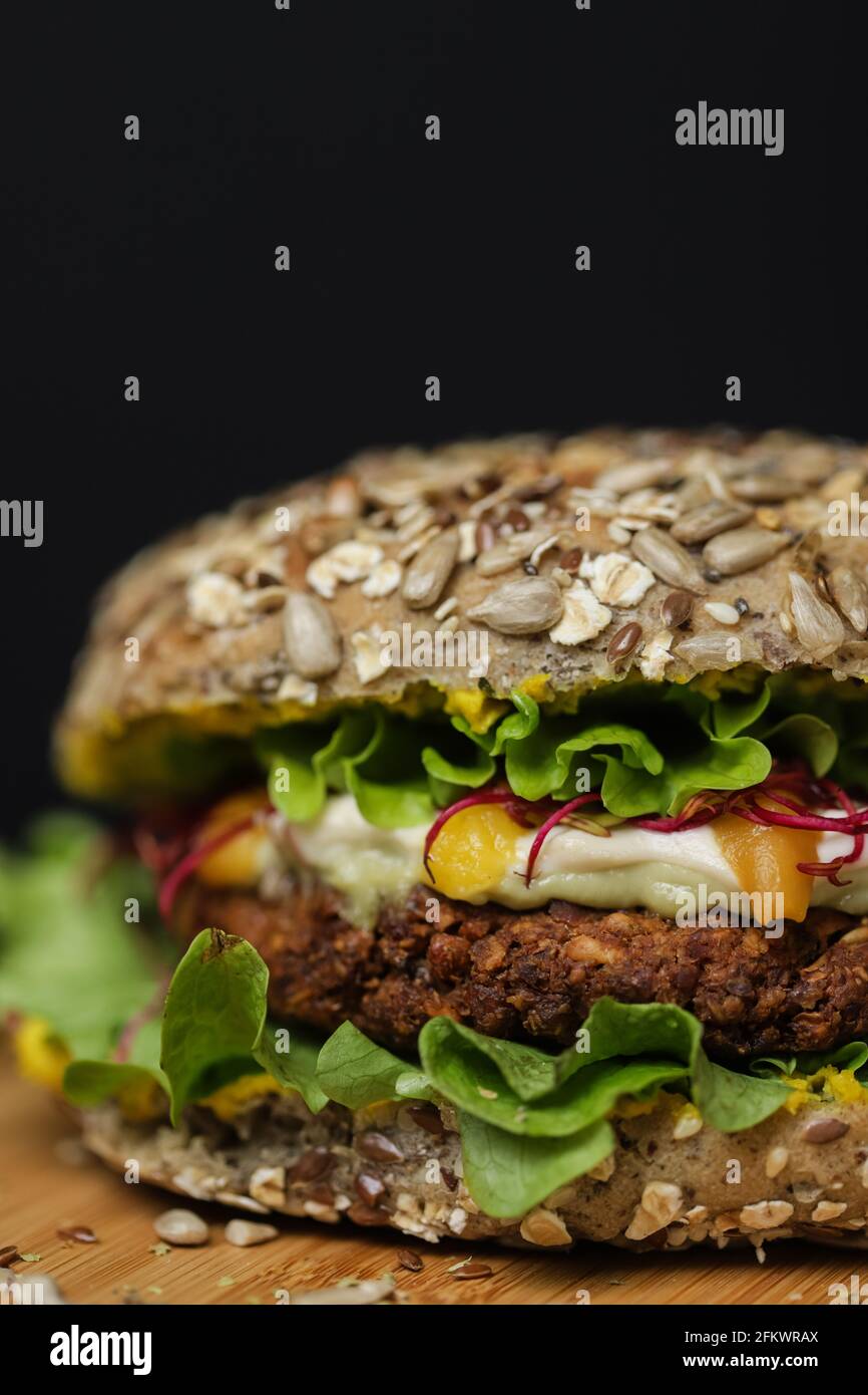 Gros plan de hamburger végétarien juteux sur une assiette en bois Banque D'Images
