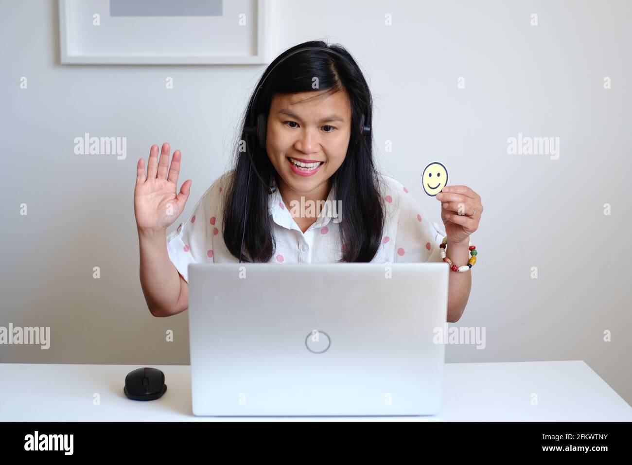 Philippine filipina asiatique femme ou fille enseignante travaillant assis devant un bureau blanc et un ordinateur d'argent, enseignant une leçon en ligne sur l'Internet Banque D'Images