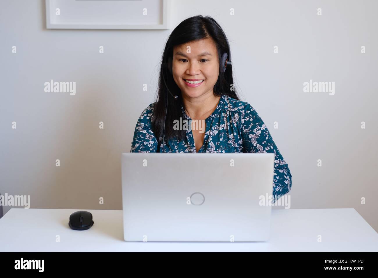 Philippine filipina asiatique femme ou fille enseignante travaillant assis devant un bureau blanc et un ordinateur d'argent, enseignant une leçon en ligne sur l'Internet Banque D'Images