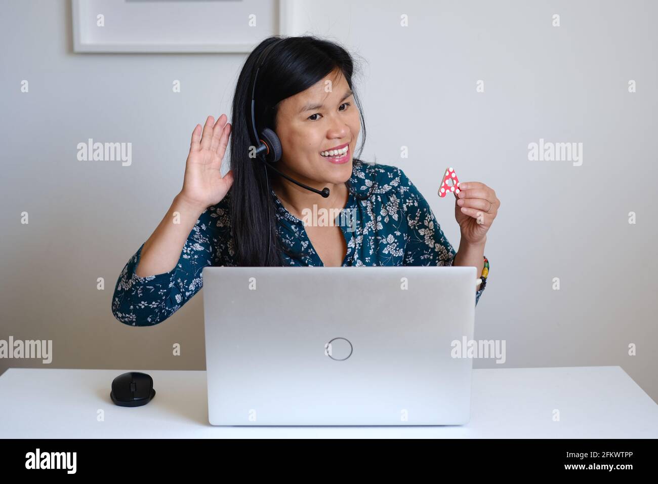 Philippine filipina asiatique femme ou fille enseignante travaillant assis devant un bureau blanc et un ordinateur d'argent, enseignant une leçon en ligne sur l'Internet Banque D'Images