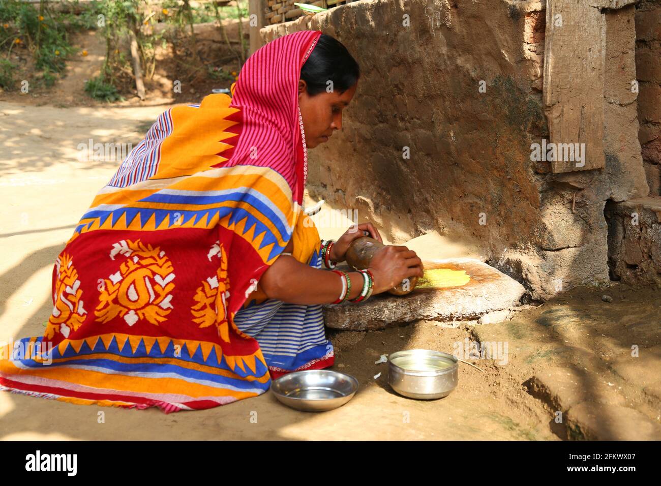 Femme de fabrication de chutney en utilisant le moulin à main traditionnel naturel de pierre à affûter appelé Sil Battas. KOLI TRIBE Cuttack, Odisha, Inde Banque D'Images