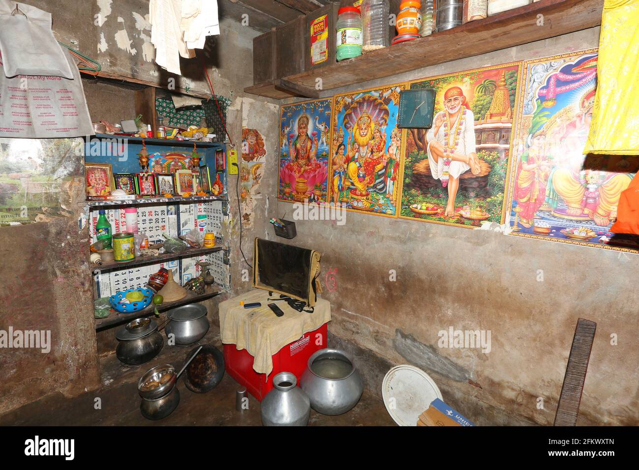 Vue intérieure du salon de la maison. Des affiches colorées de Dieu hindou, Déesse sont collées sur les murs. TRIBU KOLI. Odasinga Jodum de Cuttack, Odisha, Inde Banque D'Images