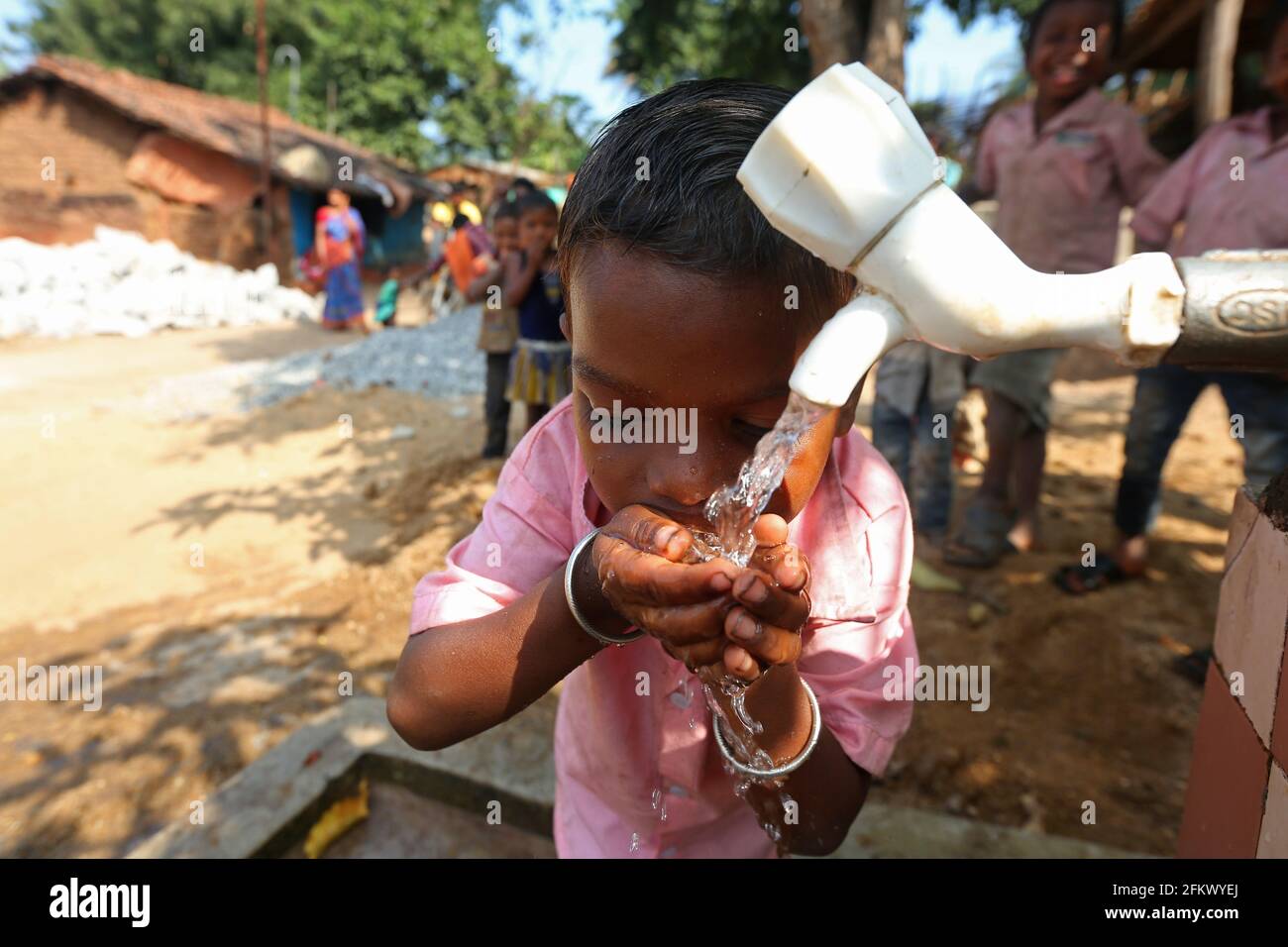 Un garçon d'école boit de l'eau au village de Lanjigadh à Odisha, en Inde. LA TRIBU DESIA KONDHA Banque D'Images