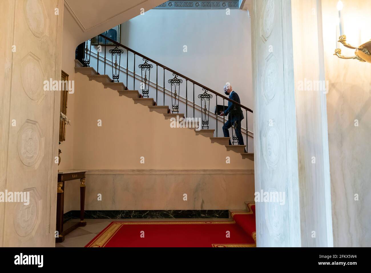 Le président Joe Biden s'est promené le lundi 5 avril 2021 dans le Grand escalier de la Maison Blanche jusqu'à la résidence privée du deuxième étage. (Photo officielle de la Maison Blanche par Adam Schultz) Banque D'Images