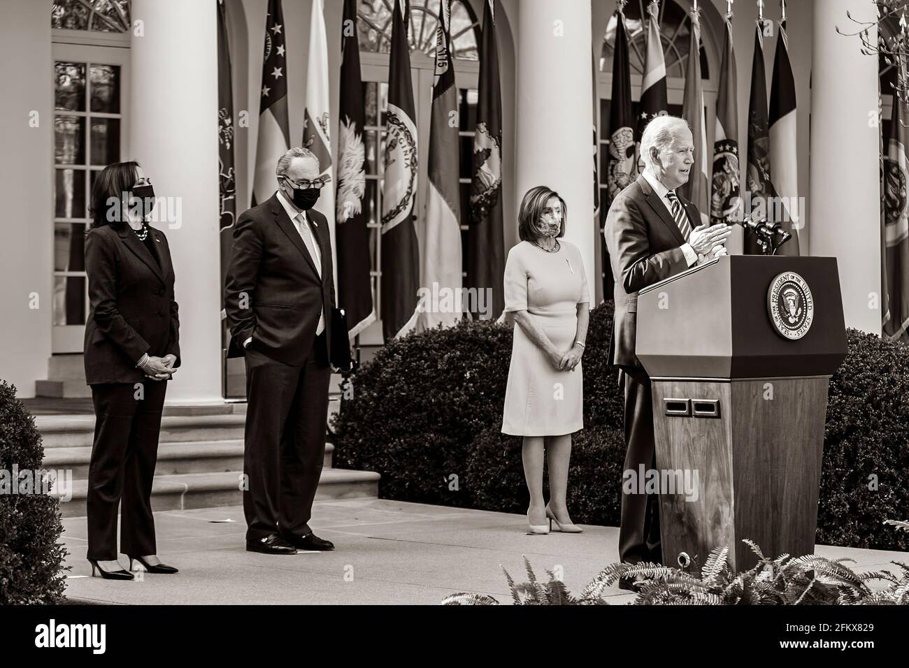 Le président Joe Biden, accompagné du vice-président Kamala Harris, de la présidente de la Chambre Nancy Pelosi, D-Californie, et du chef de la majorité au Sénat Charles Chuck Schumer, D-N.Y., prononce des remarques sur le plan de sauvetage américain le vendredi 12 mars 2021, dans le jardin des roses de la Maison Blanche. (Photo officielle de la Maison Blanche par Adam Schultz) Banque D'Images