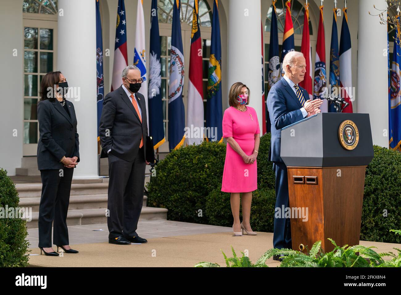 Le président Joe Biden, accompagné du vice-président Kamala Harris, de la présidente de la Chambre Nancy Pelosi, D-Californie, et du chef de la majorité au Sénat Charles Chuck Schumer, D-N.Y., prononce des remarques sur le plan de sauvetage américain le vendredi 12 mars 2021, dans le jardin des roses de la Maison Blanche. (Photo officielle de la Maison Blanche par Adam Schultz) Banque D'Images