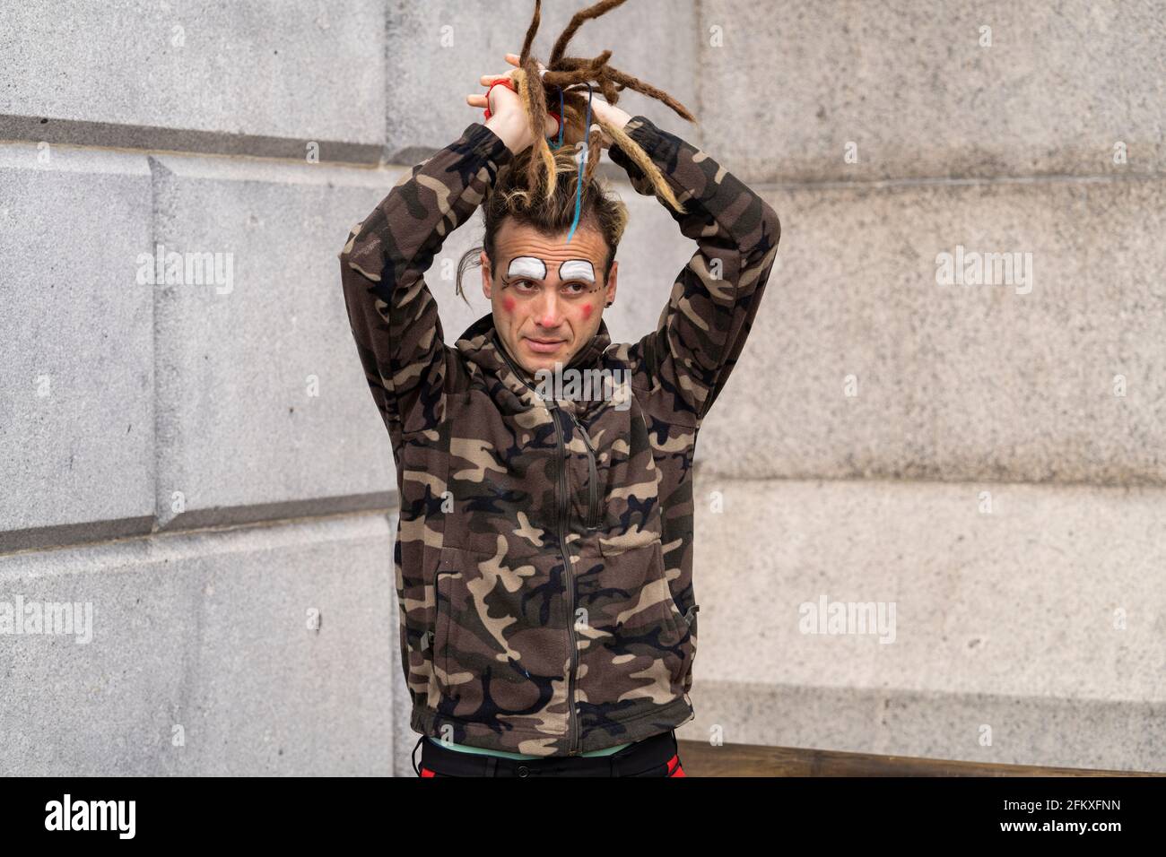 LONDRES, Royaume-Uni – 1er mai 2021 : portrait d'un manifestant pendant la manifestation Kill the Bill. Mâle caucasien avec le visage peint comme un clown et blonde dreadlocks Banque D'Images