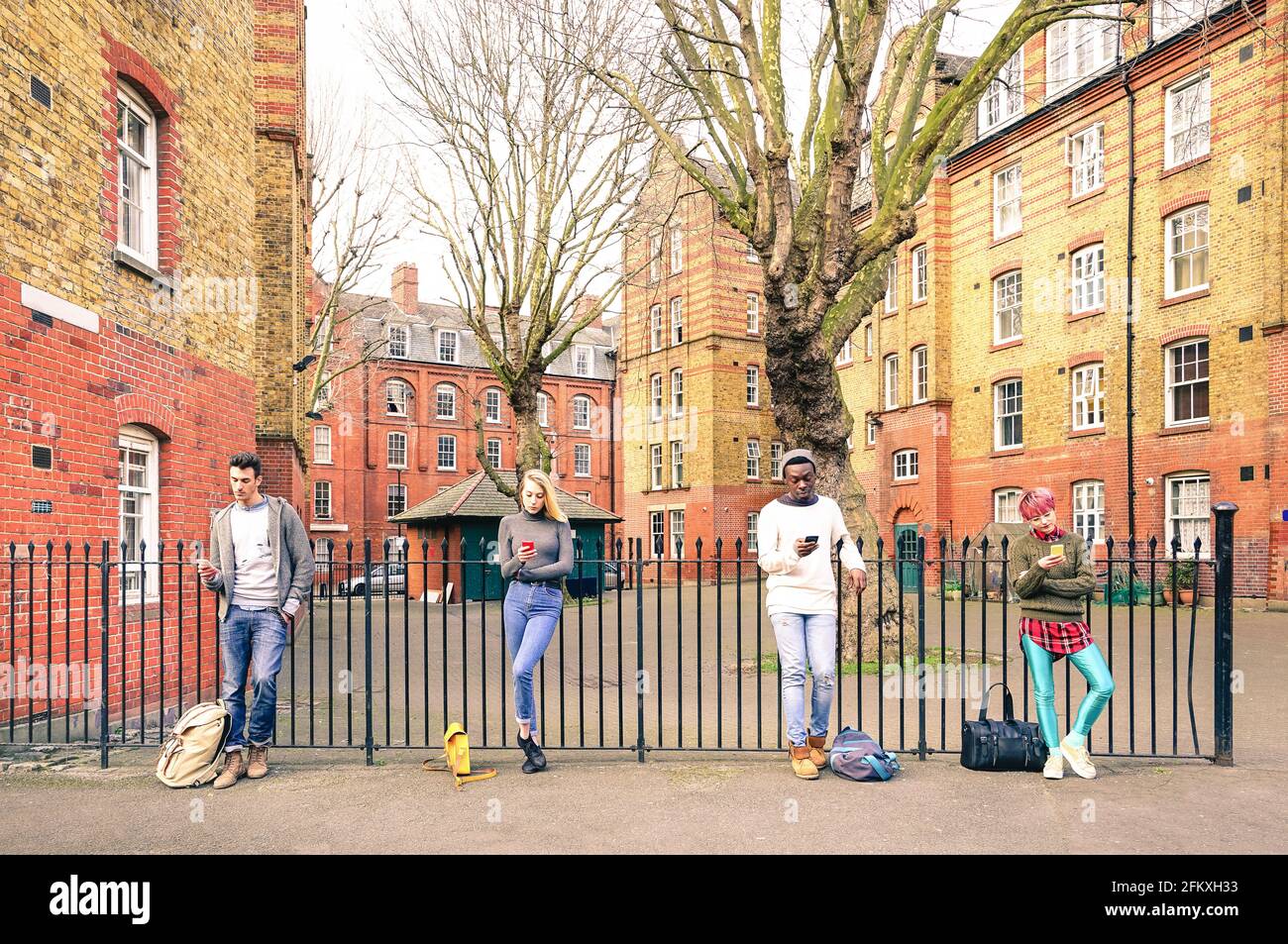 Groupe multiracial de personnes et amis urbains à l'aide d'un smartphone près de Shoreditch Londres - la dépendance de la technologie concept de style de vie avec les mecs et filles Banque D'Images