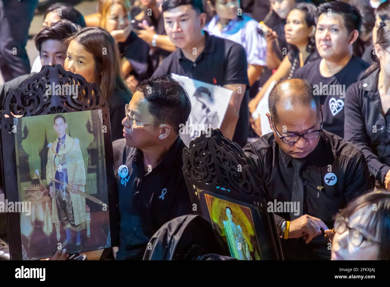Des tournants en noir avec des photographies du roi Bhumibol lors de la cérémonie funéraire, Bangkok, Thaïlande Banque D'Images