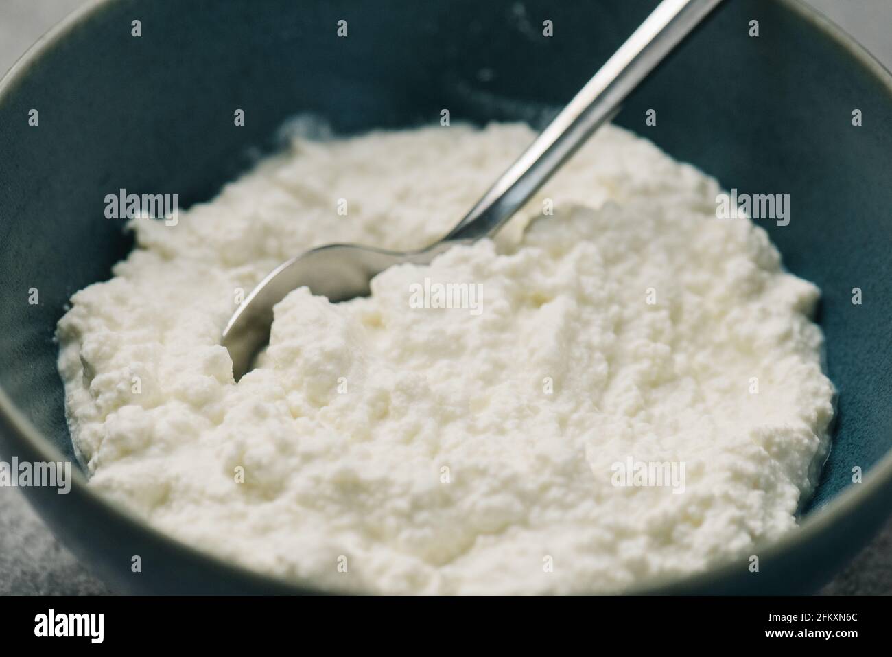 Bol de ricotta maison fraîche avec une cuillère Banque D'Images