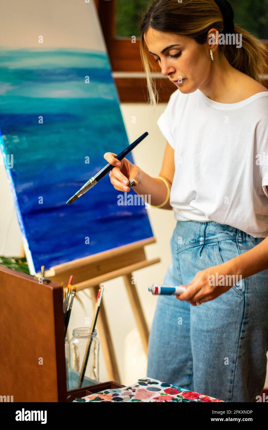 jeune fille blonde prenant bouton acrylique bleu sur la classe virtuelle Banque D'Images