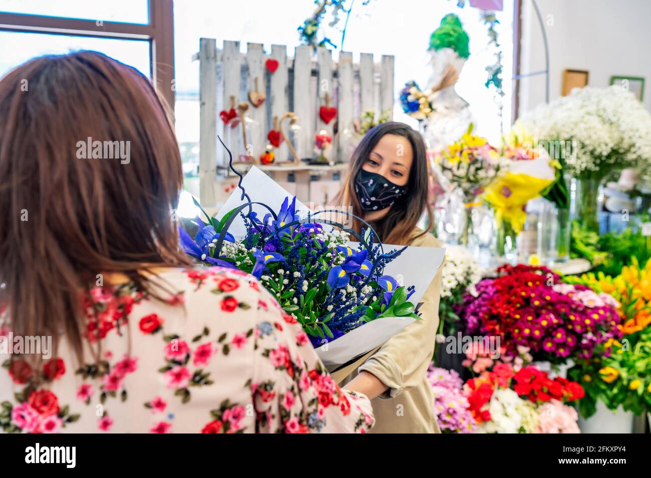 femme entreprenante donnant un bouquet de fleurs à son client Banque D'Images