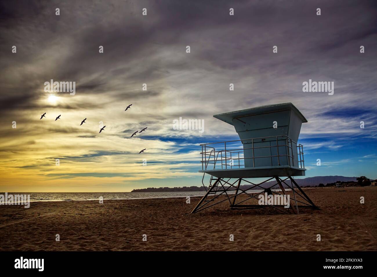 Station de surveillance de la vie sur Stinson Beach en Californie au coucher du soleil avec un troupeau d'oiseaux survolant. Banque D'Images