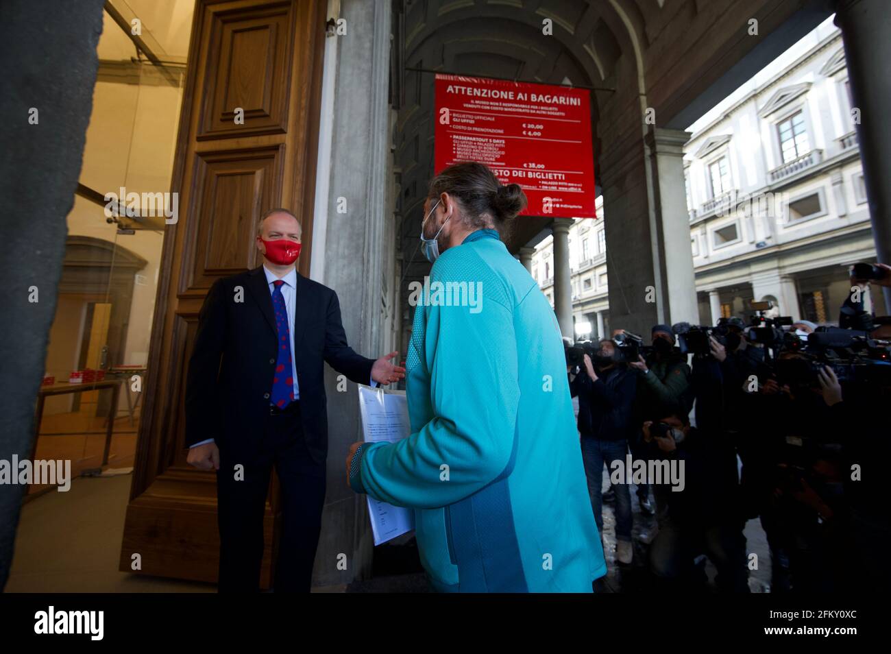 Florence, Italie. 4 mai 2021. Eike Schmidt (L), directeur des Galeries Uffizi, accueille le premier visiteur des Galeries Uffizi rouvertes à Florence, en Italie, le 4 mai 2021. Les galeries des Offices de Florence, qui abritent de nombreuses œuvres les plus importantes de la Renaissance italienne, ont rouvert leurs portes mardi. Credit: STR/Xinhua/Alay Live News Banque D'Images