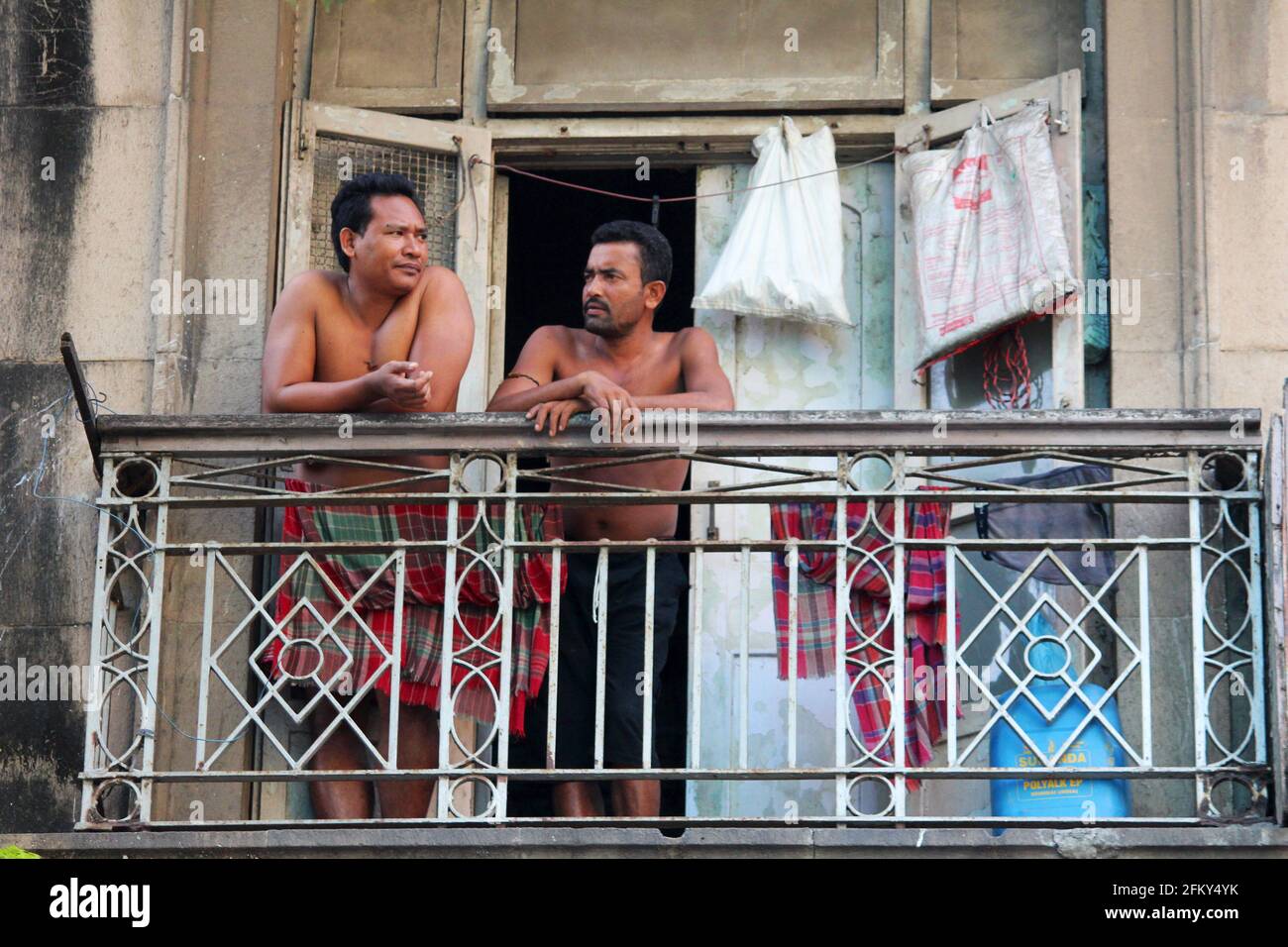 Deux hommes sur un balcon ayant une discussion , portrait de rue, Mumbai, Maharashtra, Inde Banque D'Images