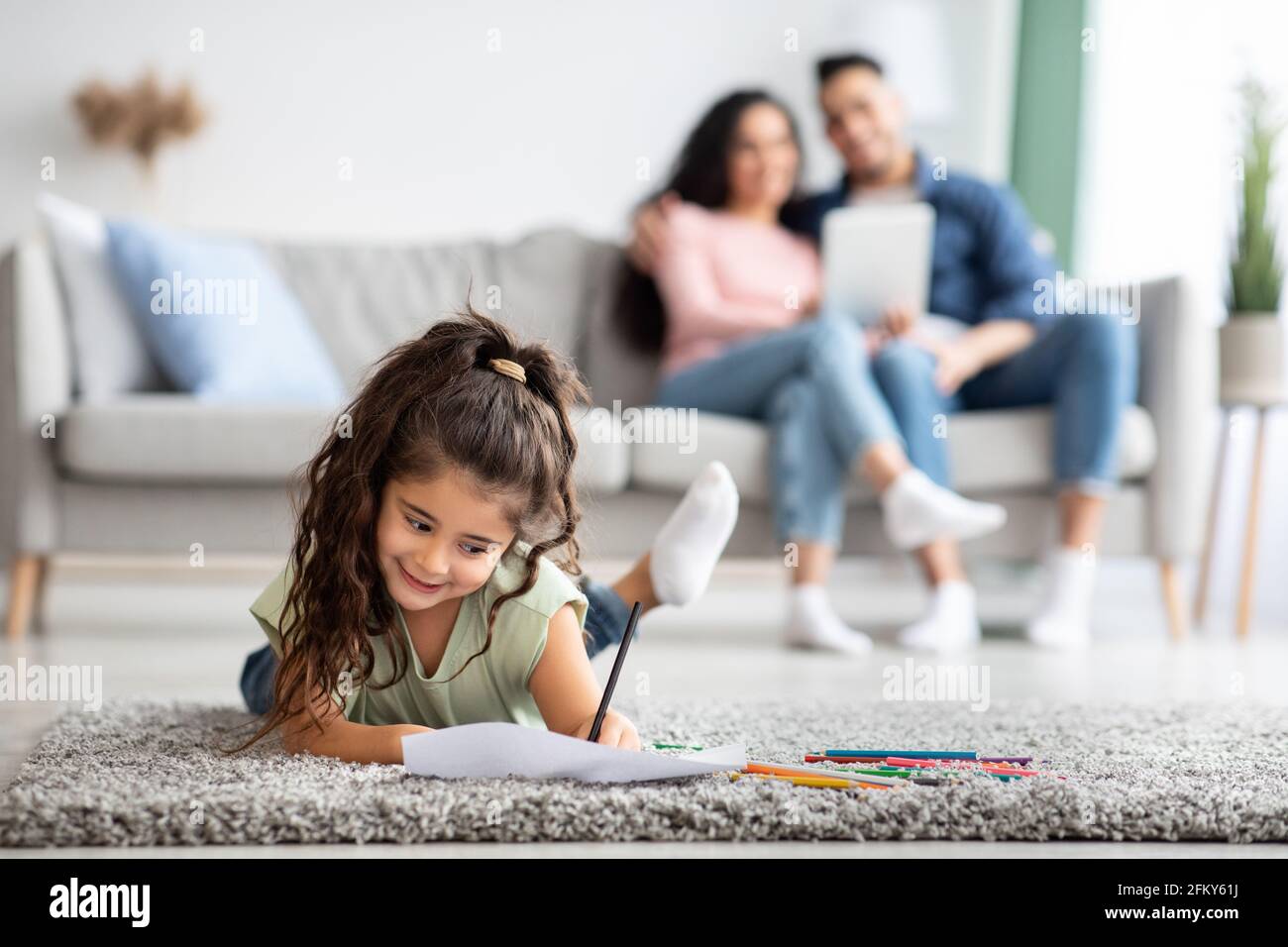 Jolie femme enfant reposant sur le sol à la maison et dessin Avec crayons Banque D'Images