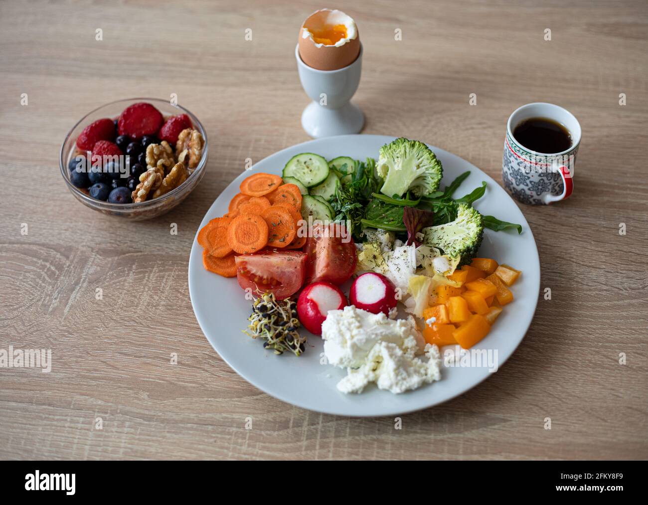 Un petit déjeuner sain et savoureux. Œuf dur, fromage cottage, légumes colorés, baies, noix et café Banque D'Images