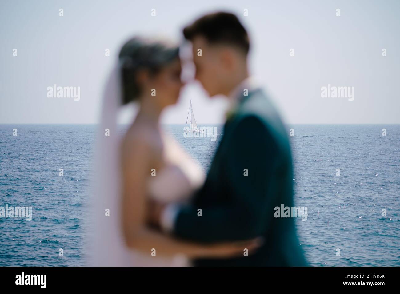 Silhouettes de jeunes mariés sur fond blanc yacht à voile dans la mer Banque D'Images