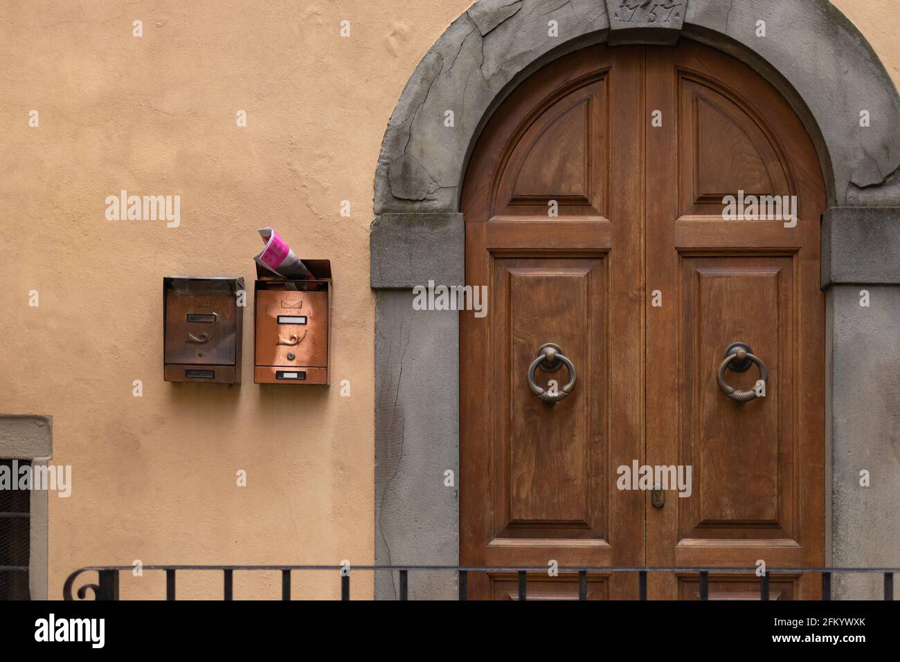 Belle porte d'entrée. Une très vieille porte de l'une des maisons de Barga vieilles de mille ans. Porte avec boîtes aux lettres en laiton. Banque D'Images