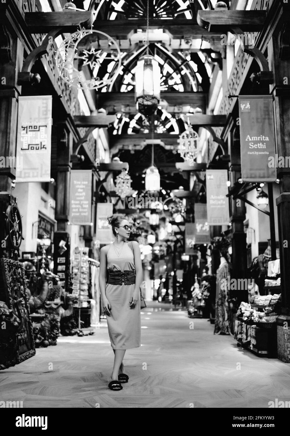 Noir et blanc. Impressionnée touriste blonde femme en robe d'été aime la marche à travers le marché de rue à Dubaï Banque D'Images