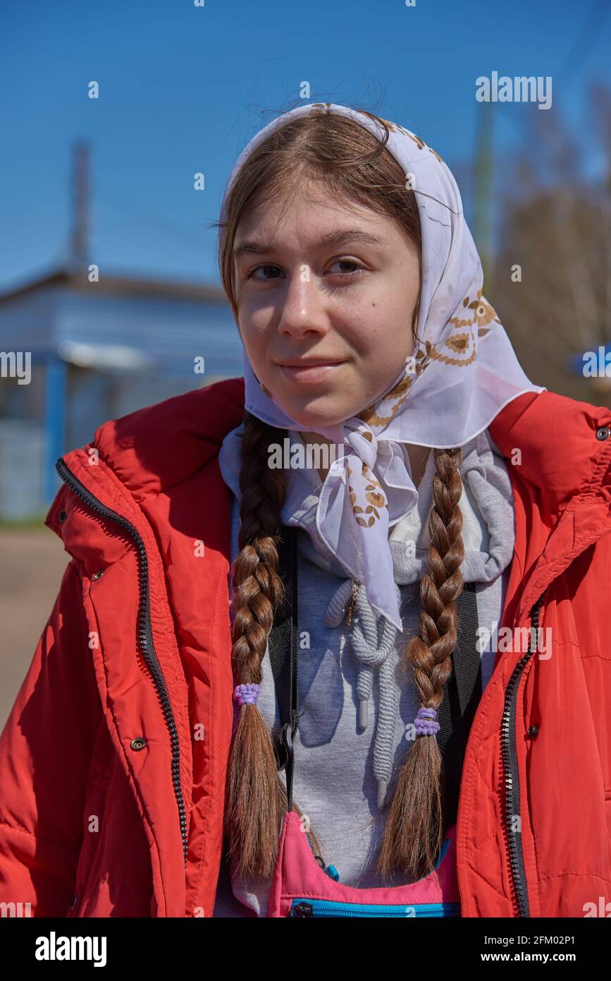 Une adolescente dans une veste rouge vif et une écharpe blanche contre le  ciel bleu Photo Stock - Alamy