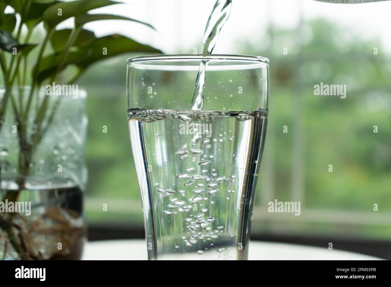 Verser de l'eau dans un verre Banque D'Images