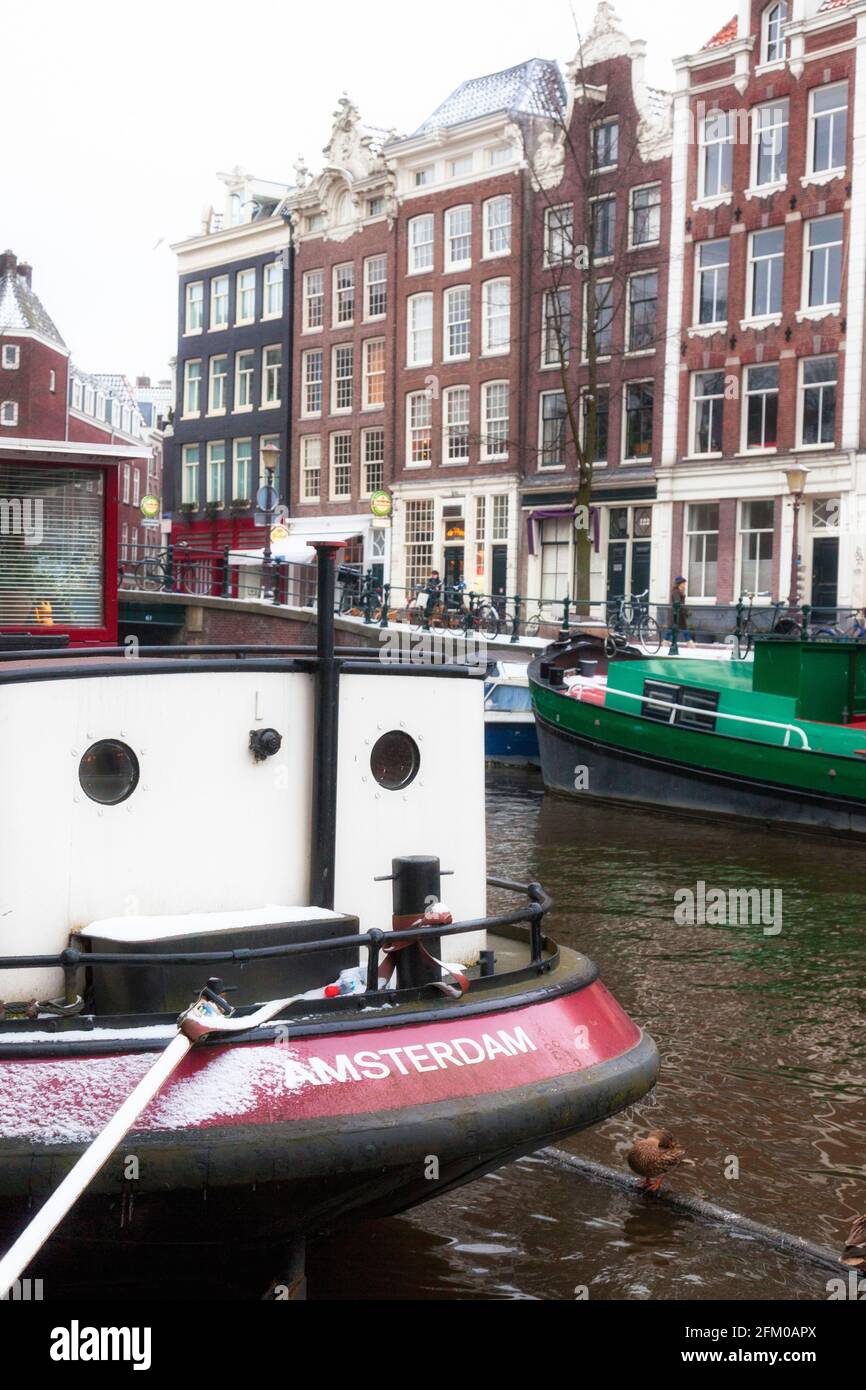 Bateaux de pêche amarrés dans le canal en hiver, Amsterdam, Hollande-du-Nord, pays-Bas Banque D'Images