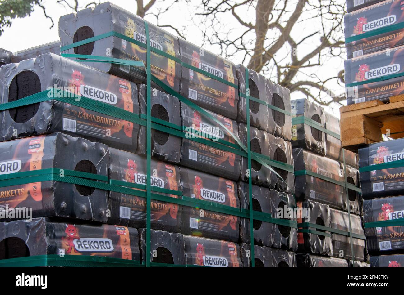 Bamberg, Allemagne - 10.4.2021. Les briquettes de charbon de bois de marque Rekord sont stockées sur une palette devant un magasin de quincaillerie Banque D'Images