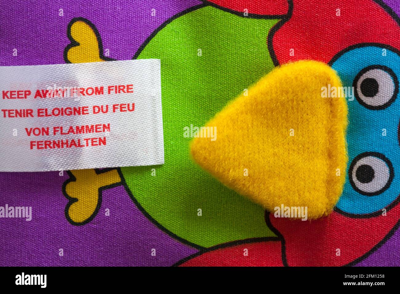 Tenir à l'écart du feu dans différentes langues sur l'étiquette livre de jouet doux pour bébé Banque D'Images