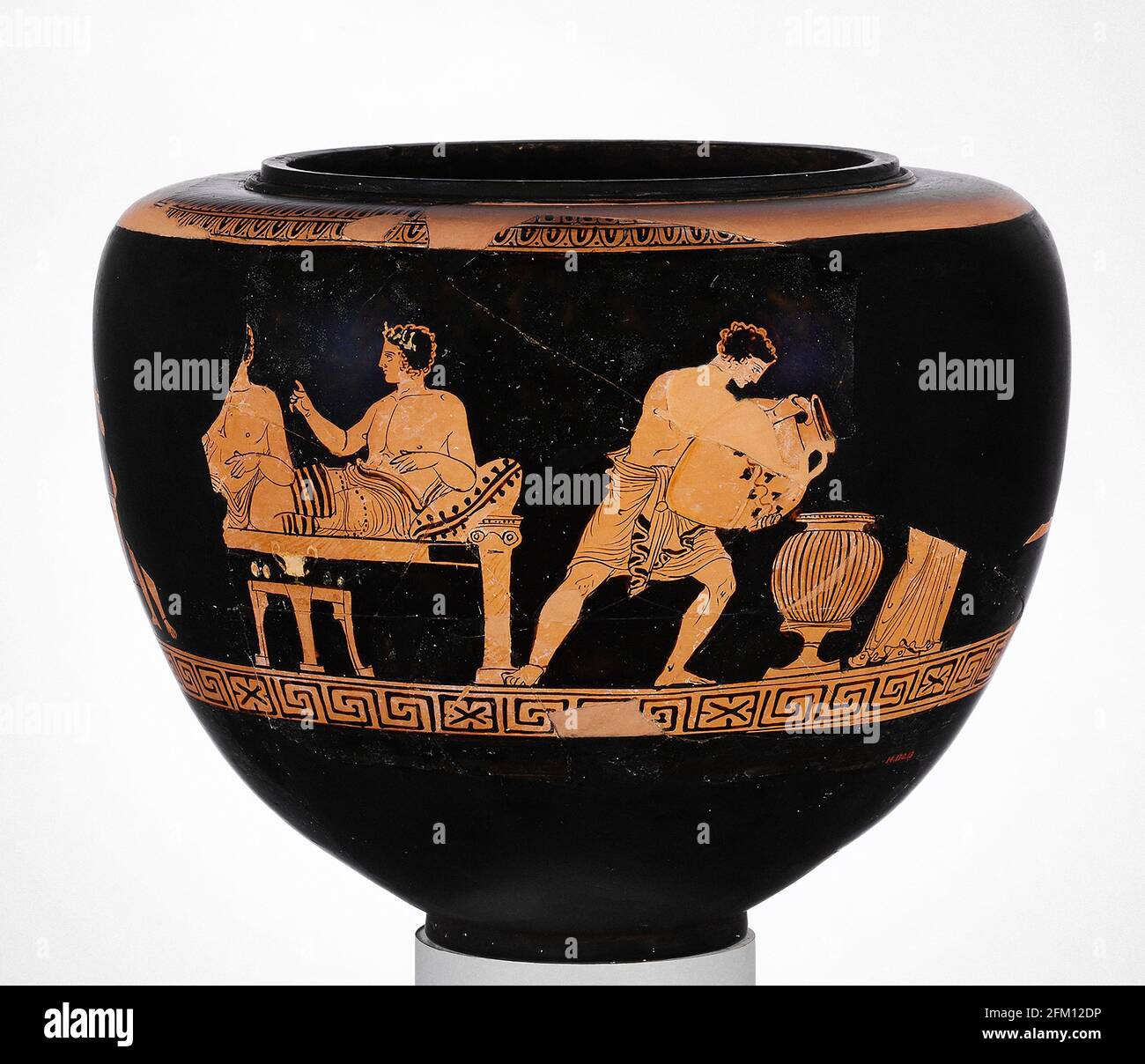 Dinos en terre cuite grecque (bol à fond rond profond) ca. 375–350 scène du banquet de la C.-B. - la scène représente les invités de sexe masculin qui s'inclinent sur des canapés et à laquelle ont assisté deux jeunes et deux femmes. Banque D'Images