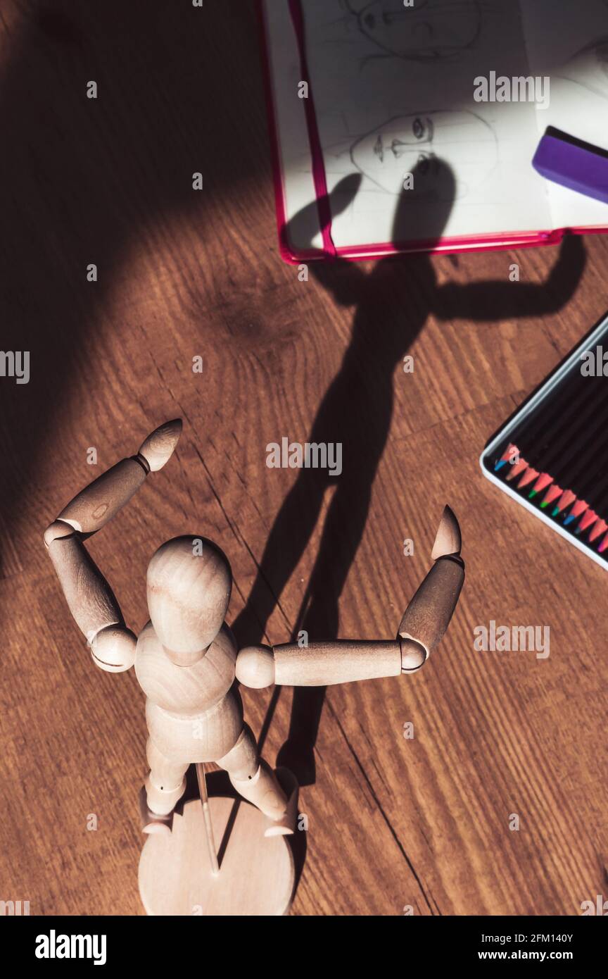 Image d'un mannequin à dessin rétroéclairé avec crayons de couleur et un carnet d'esquisses Banque D'Images