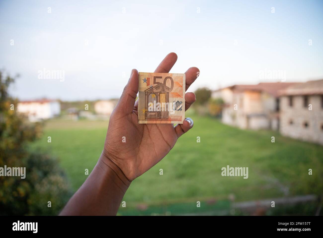 billet de 50 euros déchiré en moitié tenu dans la main par un garçon Banque D'Images