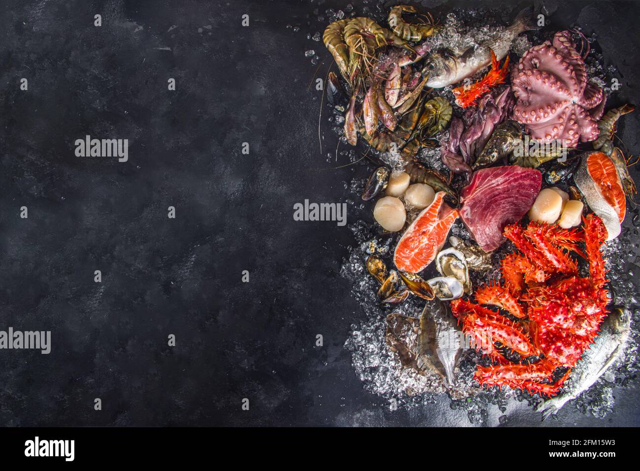 Ensemble de divers fruits de mer frais crus - pieuvre, crabe, calmar, crevettes, huître, moules, saumon thon dorada poisson avec épices d'herbes citron, dos noir Banque D'Images